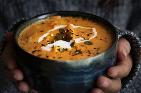 Woman holding a bowl of soup food photography recipe idea